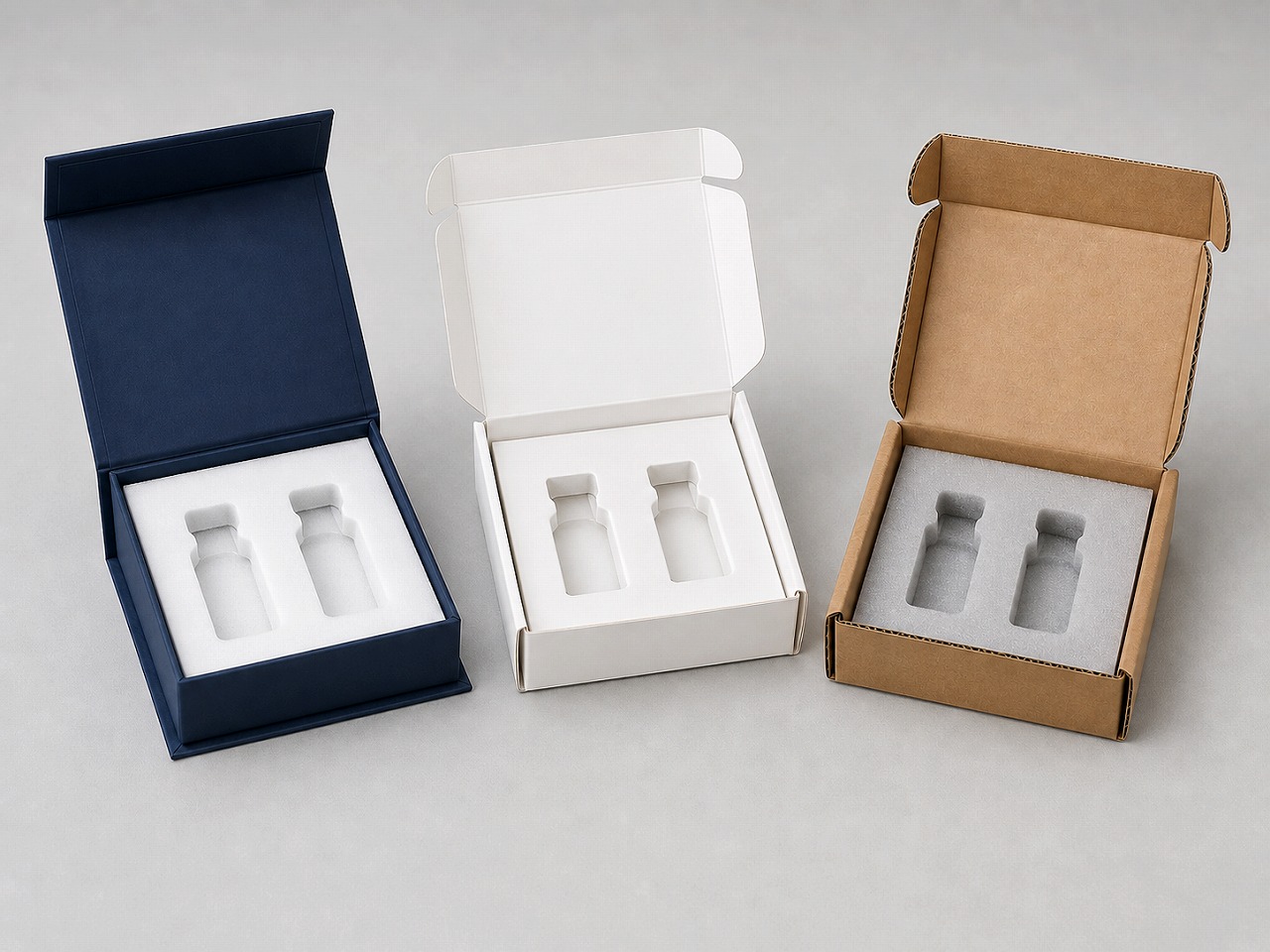 Three realistic two-slot vial packaging prototypes using rigid board, folding carton, and corrugated structures